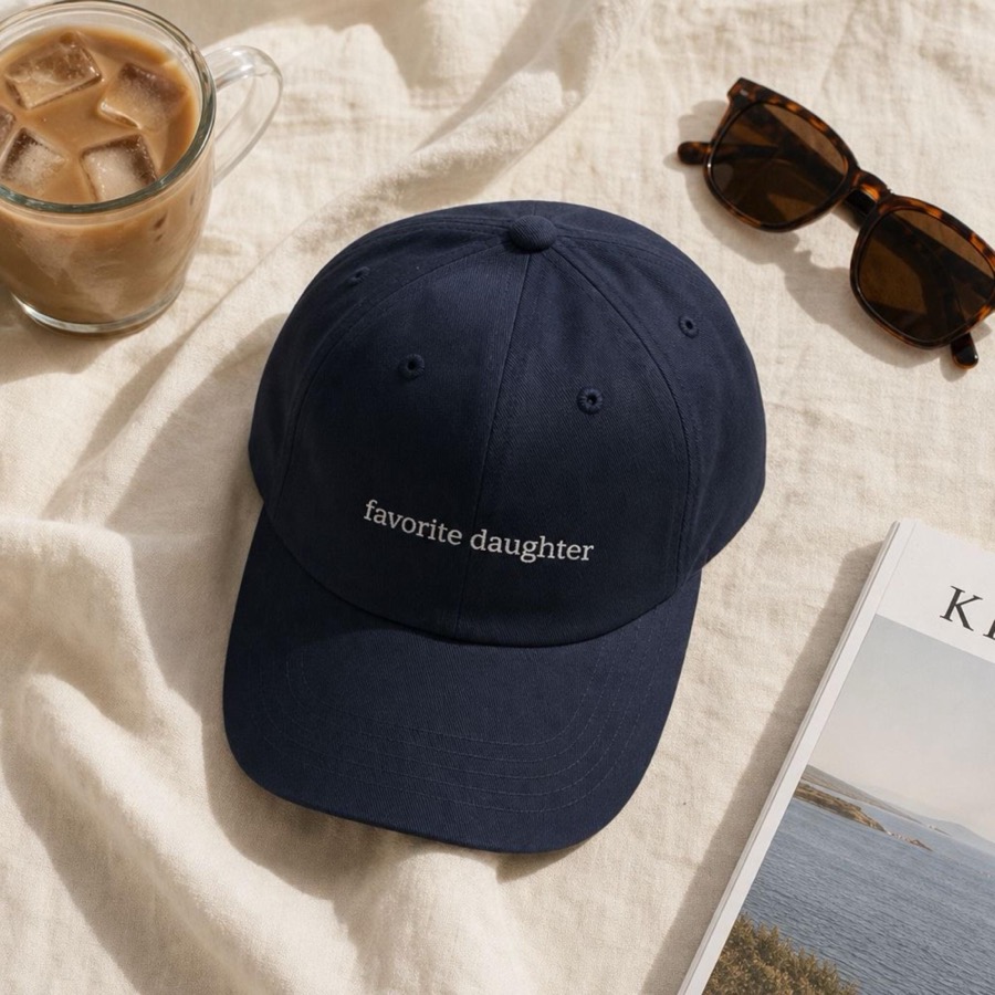 Navy embroidered dad hat reading favorite daughter, styled with iced coffee and sunglasses